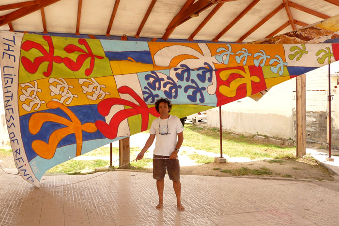 Piaf,artiste surfeur,un pied sur la board une main sur la toile